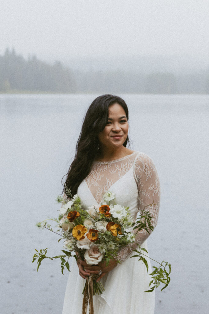 bride wearing wedding dress and floral bouquet at lakeside elopement
