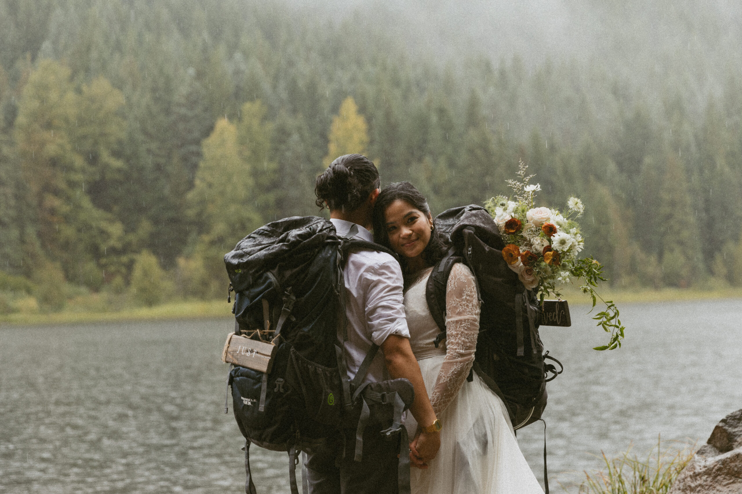 Bridge and groom hike in the rain to elope at alpine lake