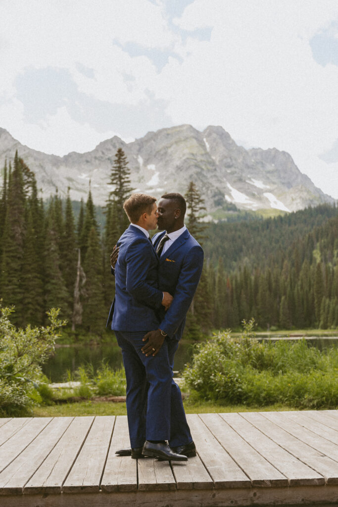 two men kiss after getting married overlooking Island Lake