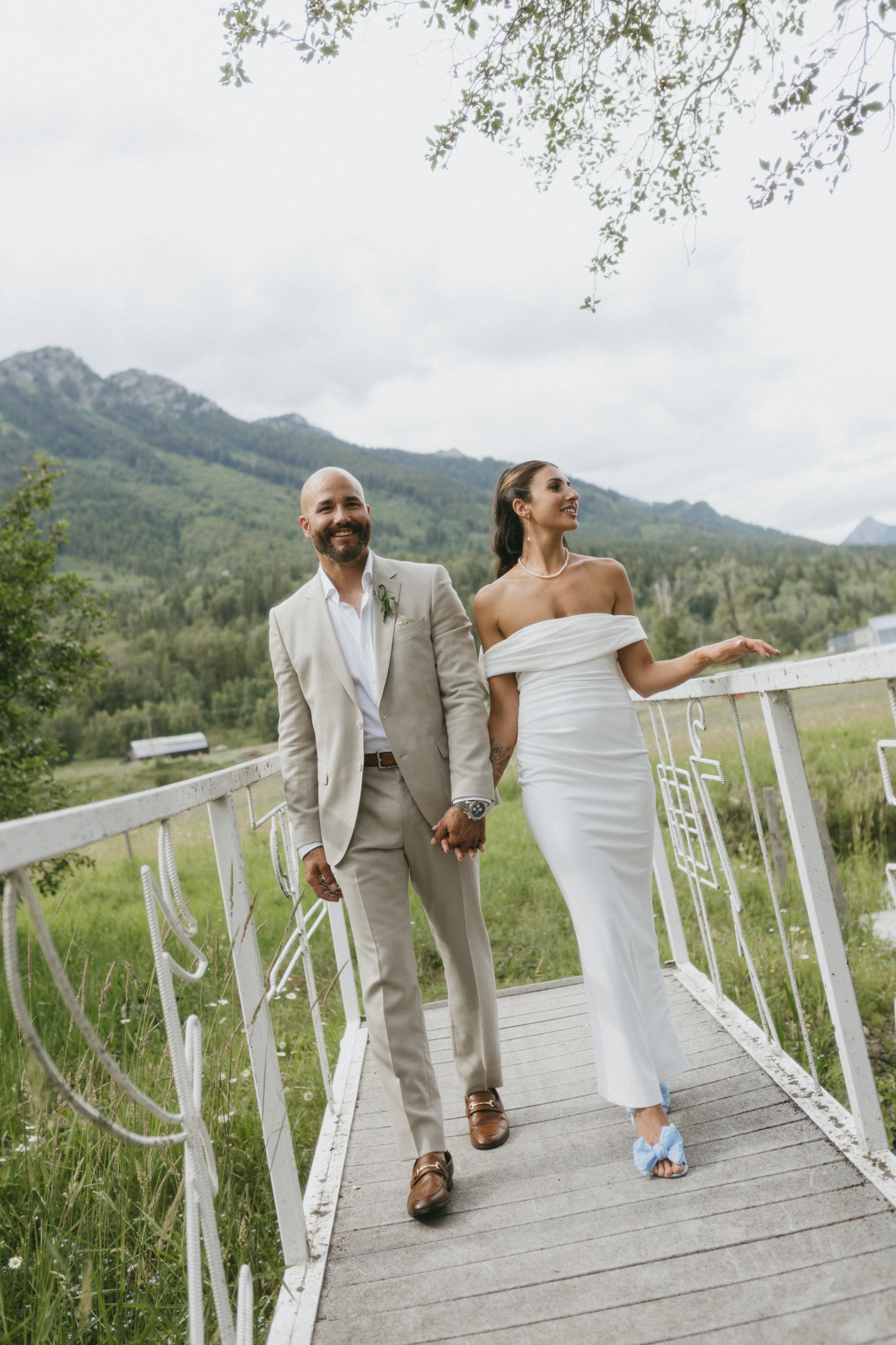 bride and groom walk across bride at their fernie wedding venue