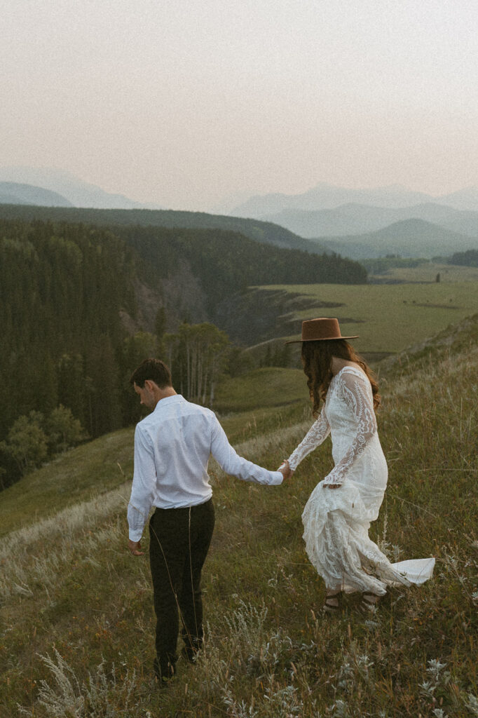 romantic bride and groom roaming the fields during their banff elopement day