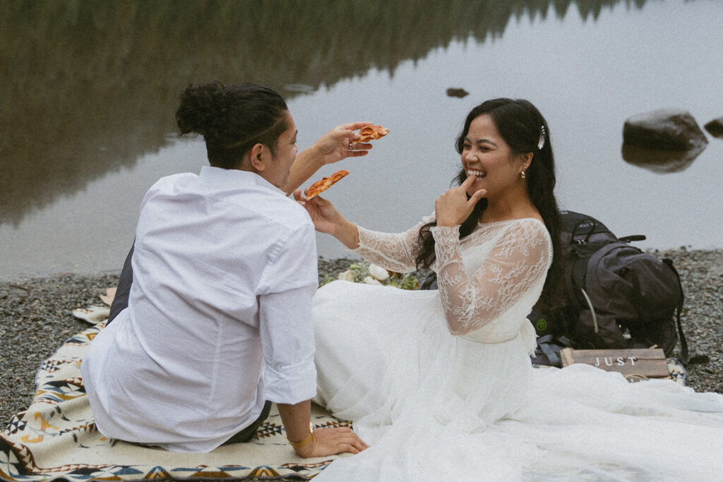 run candid bride and groom photo of them having a picnic by a lake