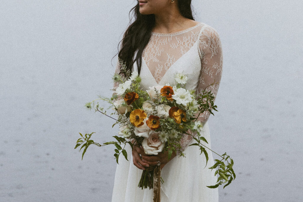 close up bridal portrait outdoors of her holding her boho styled elopement bouquet