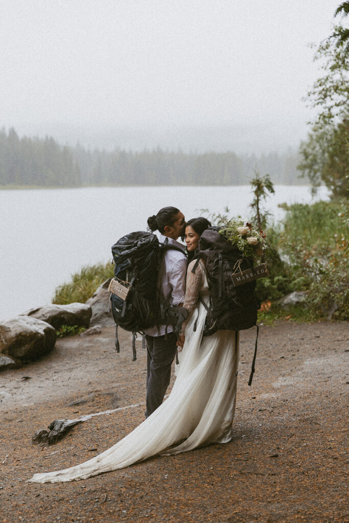 adventurous bride and groom with backpacks going hiking for their banff elopement 