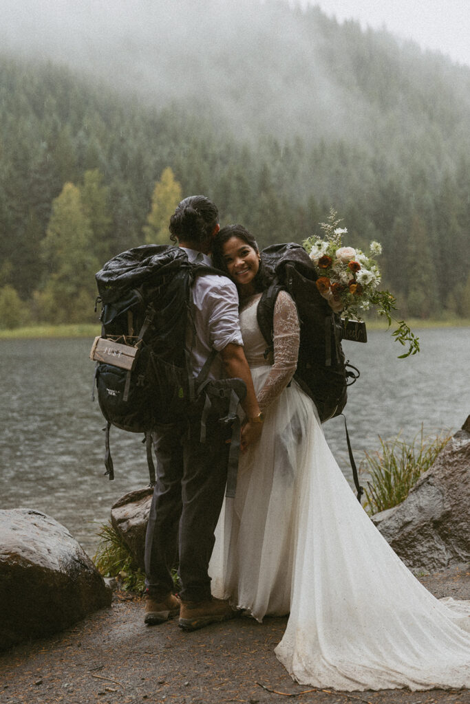 adventurous bride and groom with backpacks going hiking for their banff elopement 