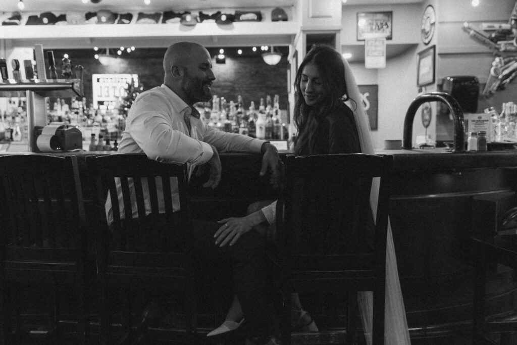 bride and groom sitting at a bar