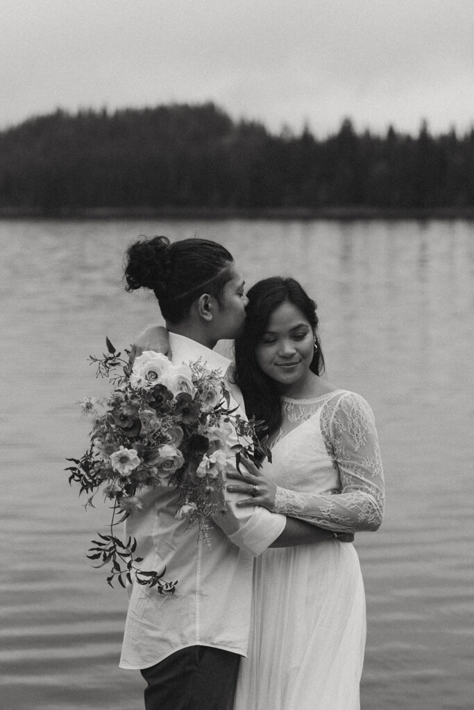 romantic bride and groom by a lake during their adventure elopement in Alberta