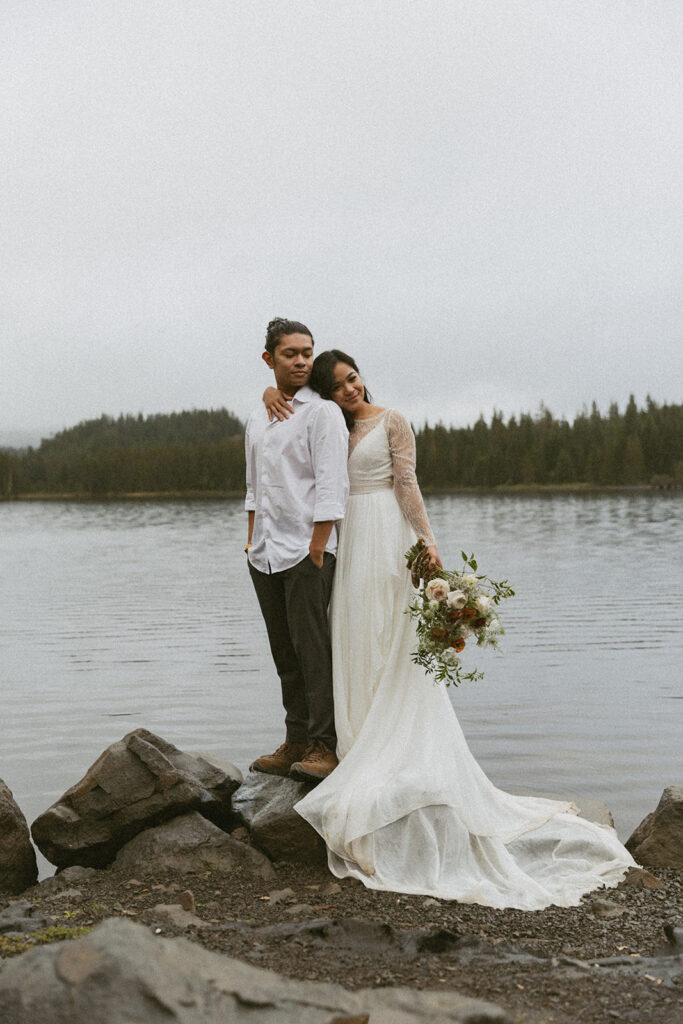 romantic bride and groom by a lake during their adventure elopement in Alberta