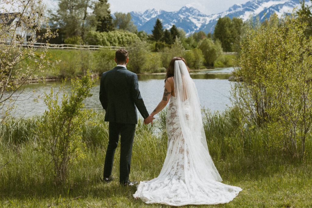 bride and groom holding hands at fernie wedding location with mountains as the backdrop