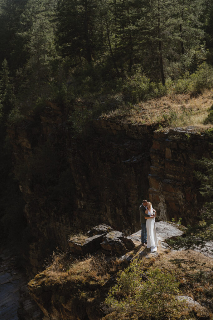 bride and groom standing on mountain at cranbrook wedding