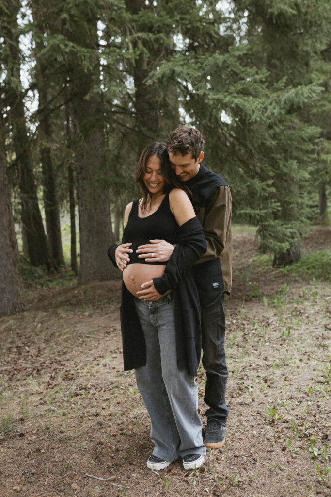 Candid moment of Caleb resting his head against Ang’s, surrounded by green woodland in Fernie