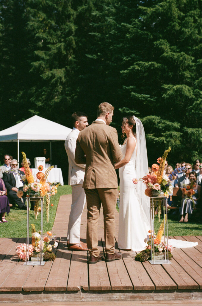 Bride and groom reading vows during outdoor ceremony at Island Lake Lodge