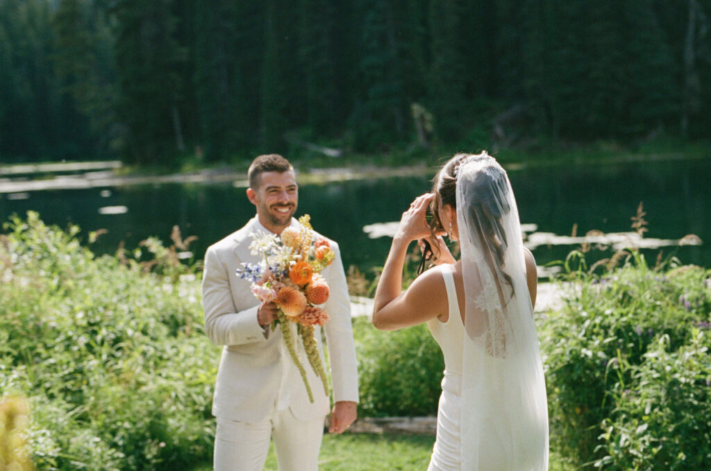 Fernie wedding couple walking by the lake at Island Lake Lodge in Fernie BC