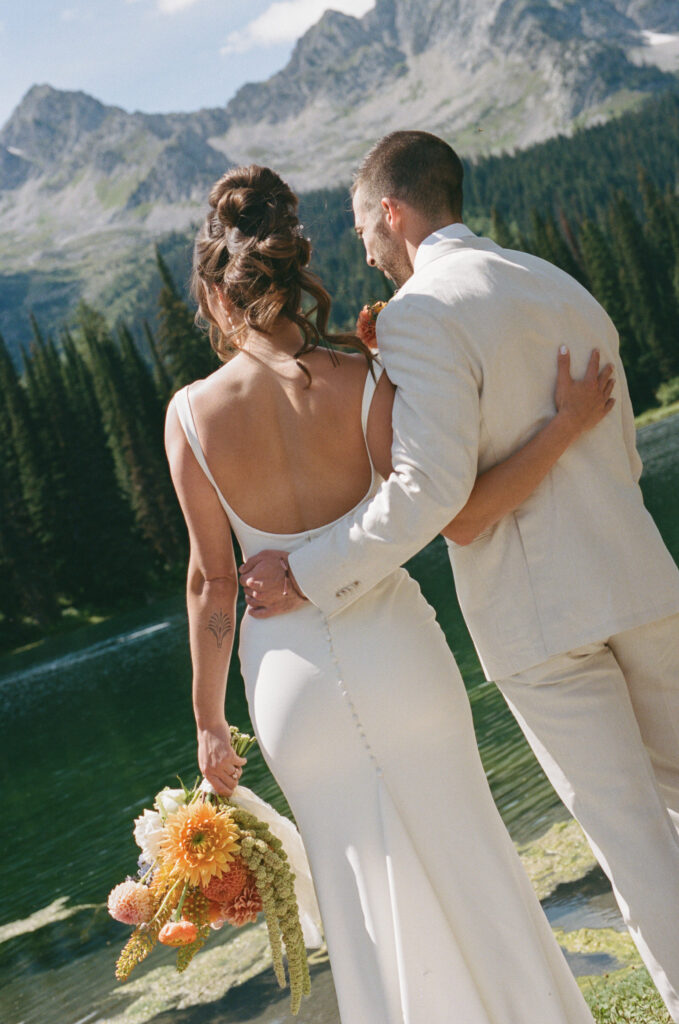 Couple’s first look under tall evergreens at Island Lake Lodge in Fernie