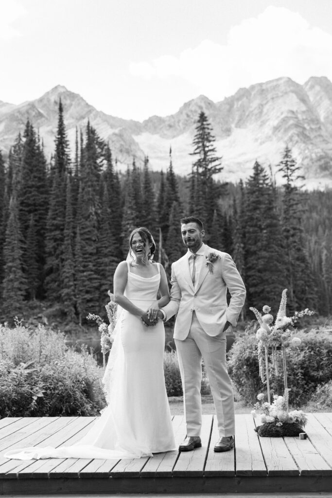 Couple looking out at guests with tears in their eyes after ceremony captured by Fernie wedding photographer